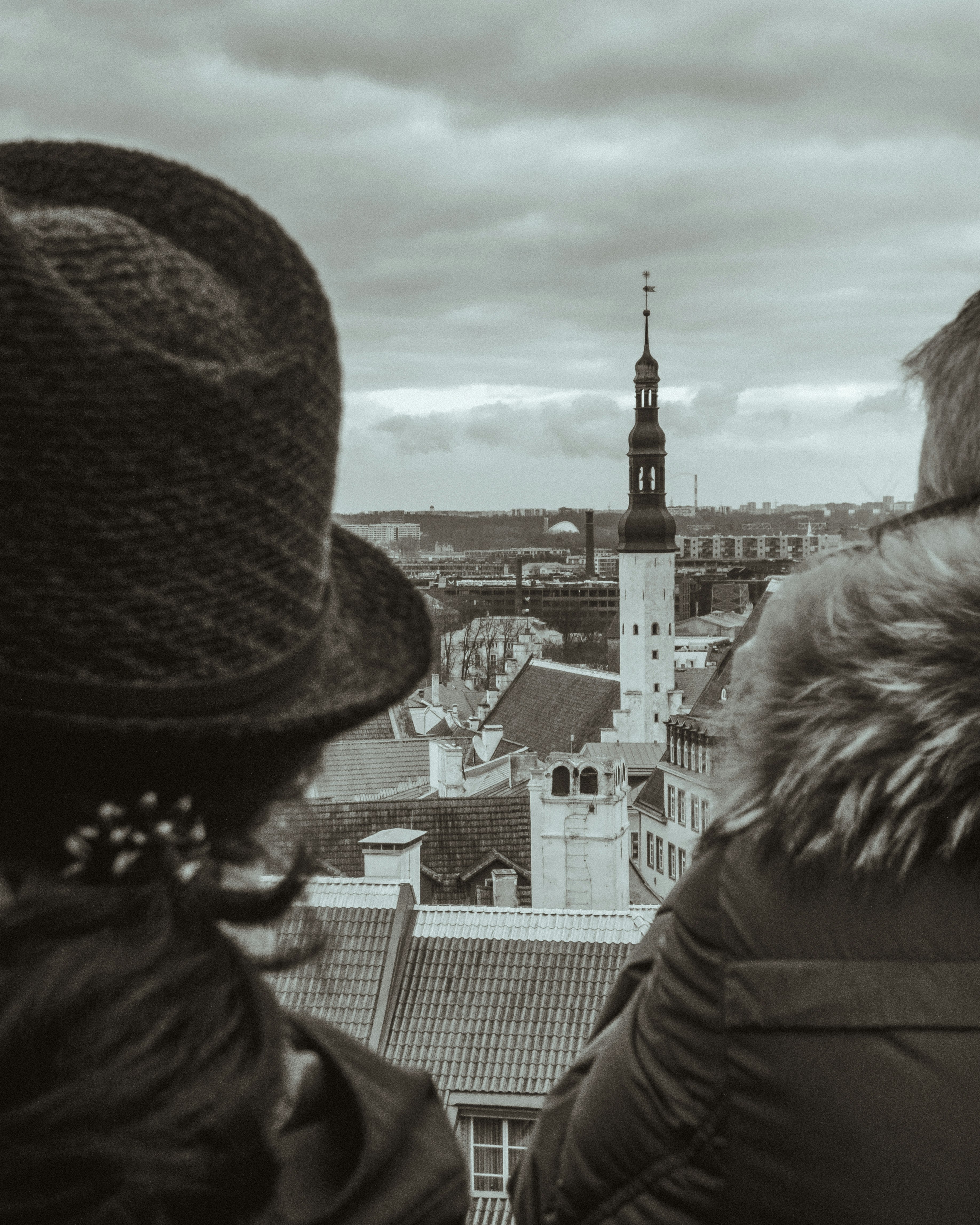 woman in black and brown parka coat standing on top of building during daytime